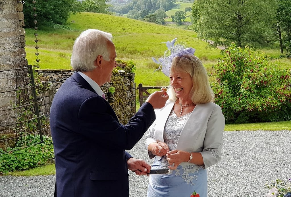 Newly married couple feeding each other wedding cake