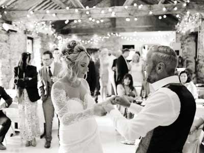 Bride and Groom dancing together at their wedding reception in the old barn at Cote How in the Lake District