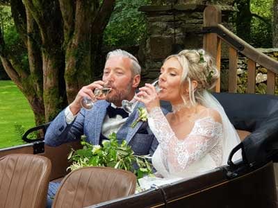 Bride and Groom sipping Prosecco in the back of a vintage Austin 7