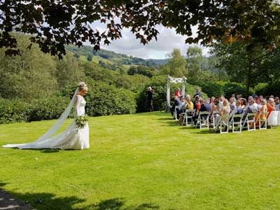 Here comes the bride entering the lawn wedding ceremony at Cote How