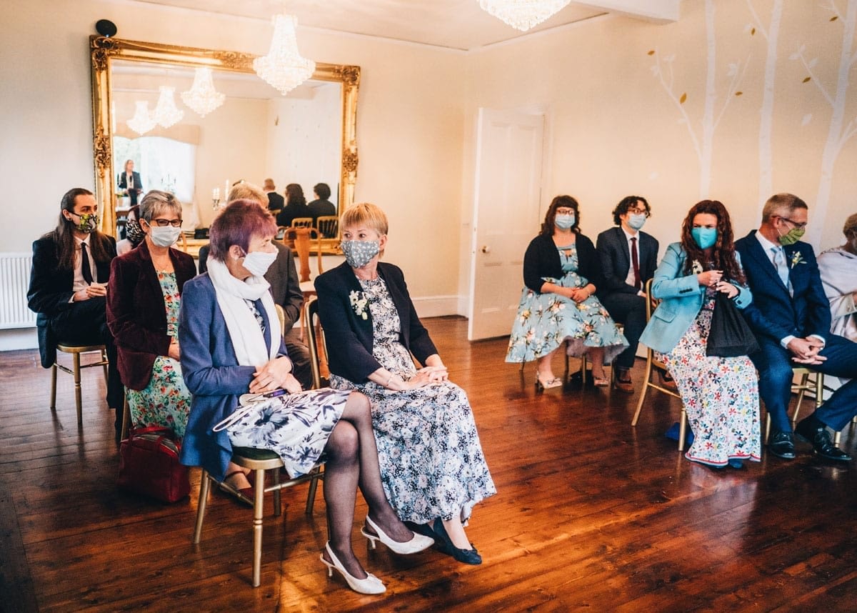 Guests seated at a Covid Secure Wedding Venue wearing face masks and socially distant