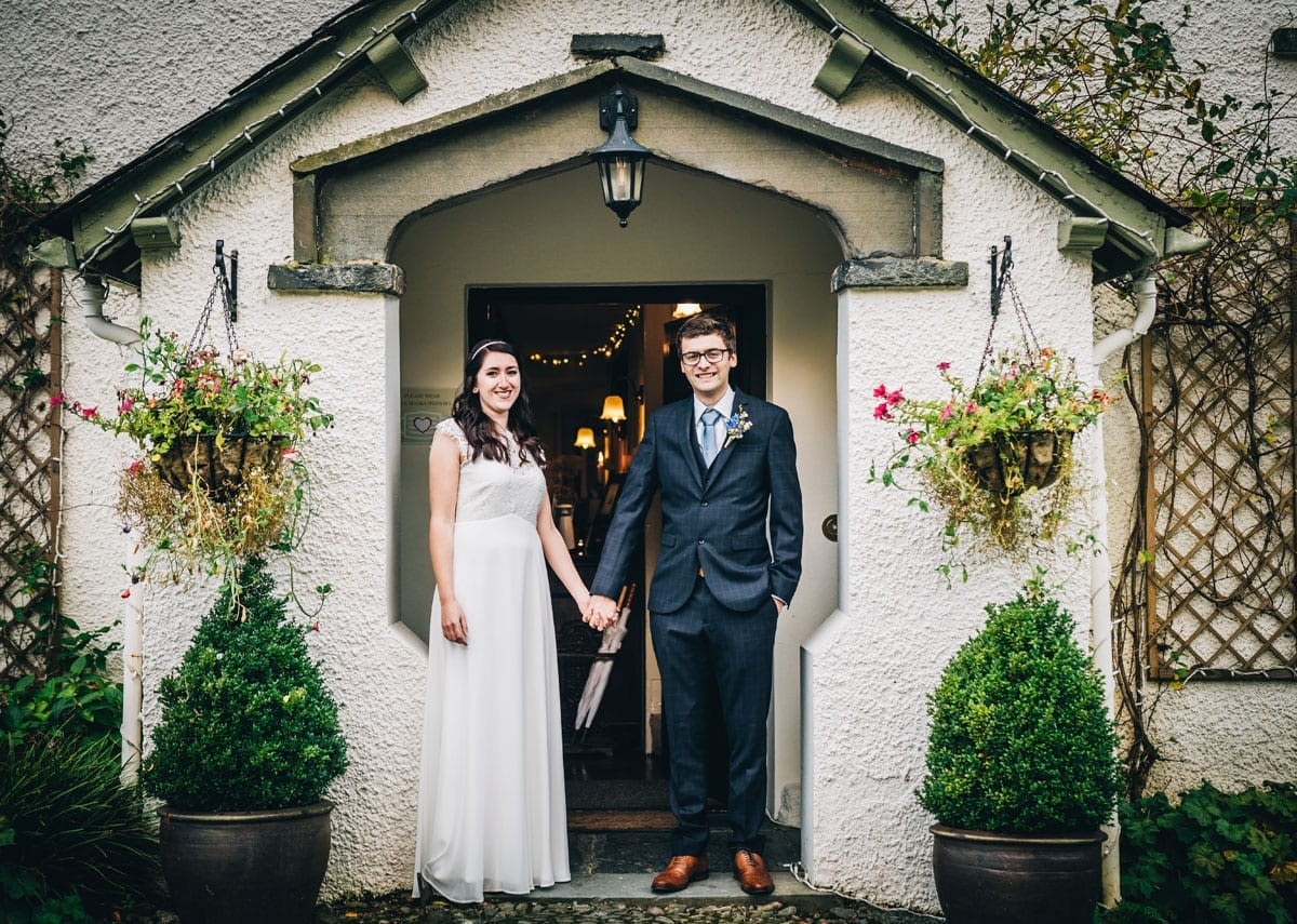 Bride and Groom standing in the Tudor porch at Cote How Lake District Wedding Venue in Rydal