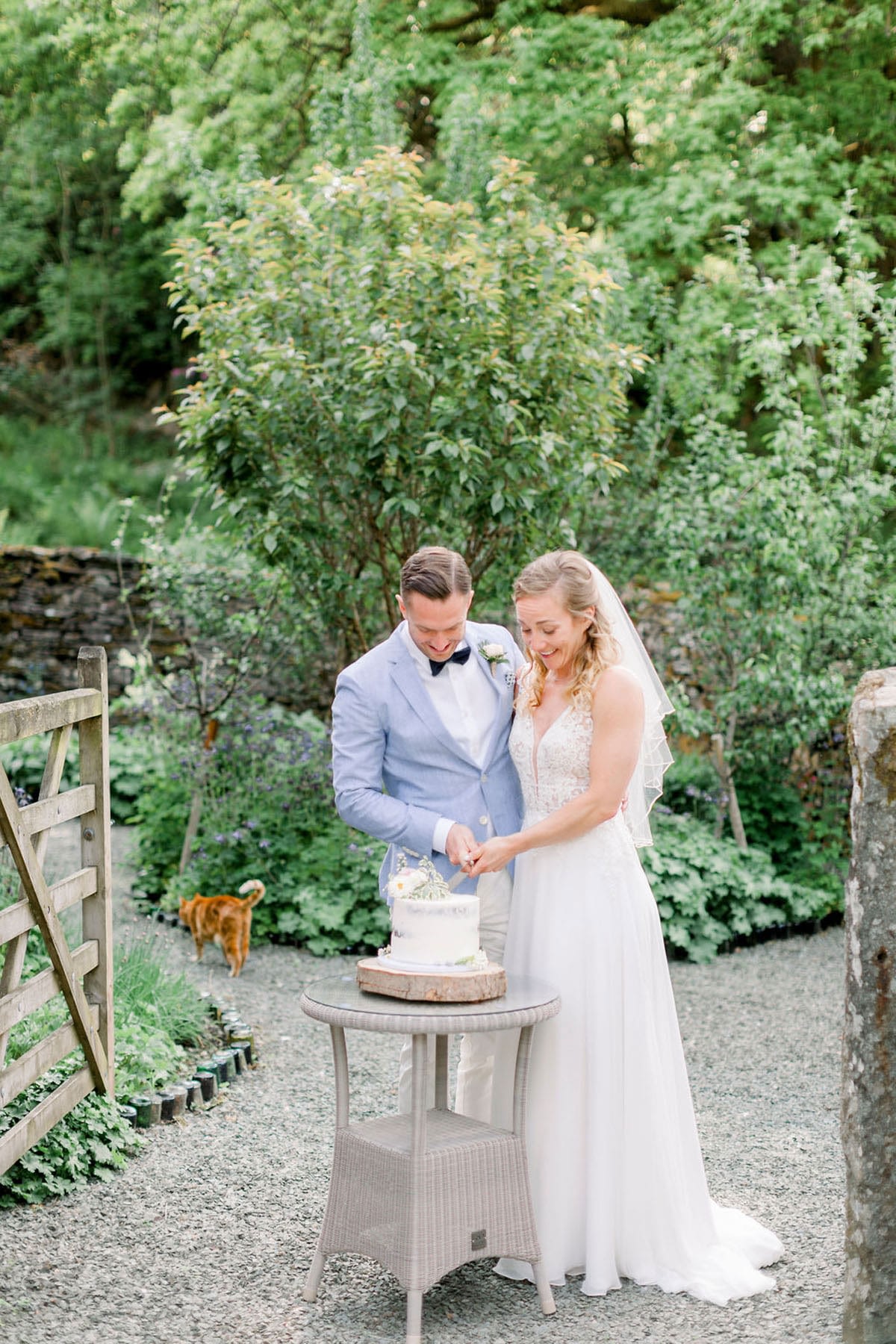 Wedding couple cutting cake outside small wedding venue