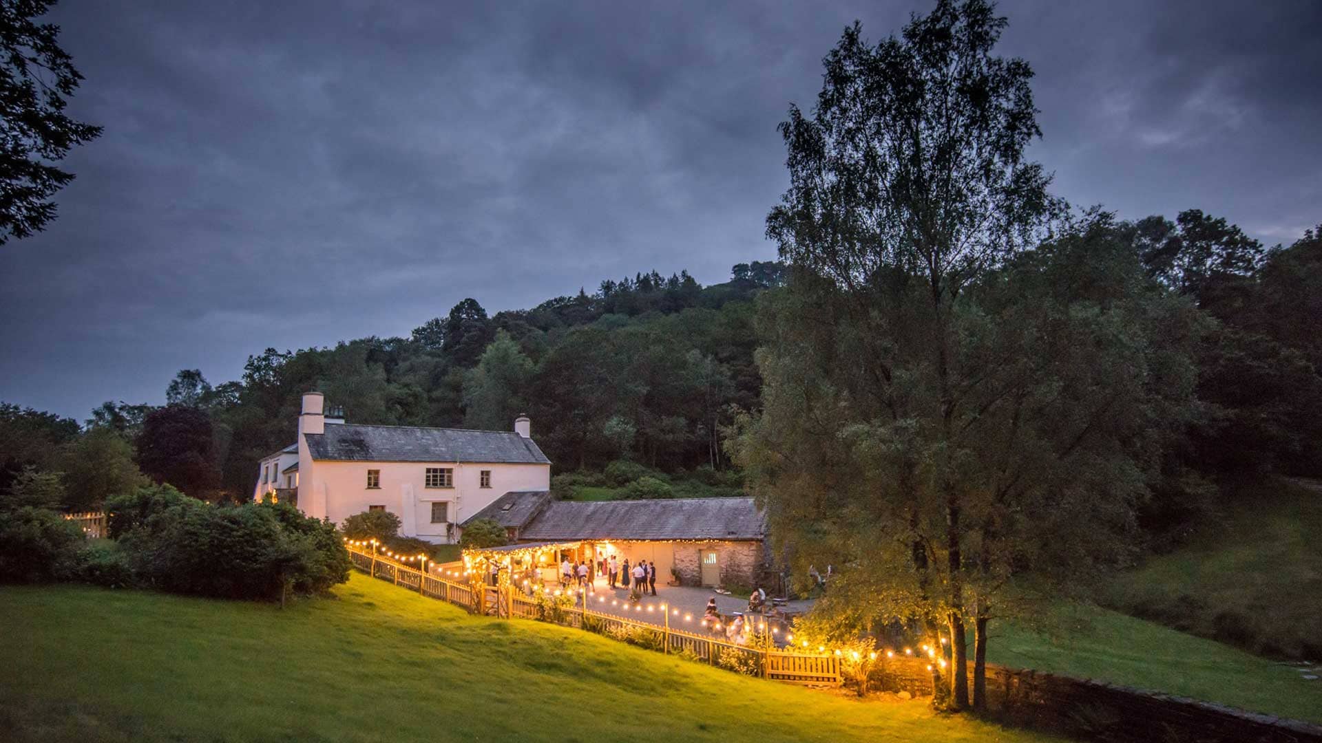 The Country House and Wedding Barn at Cote How illuminated at dusk twilight
