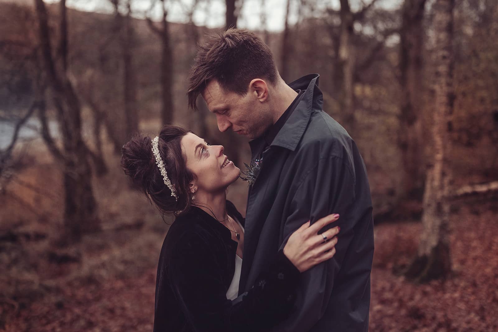 Jo and Fred looking at each other in woods by Cote How