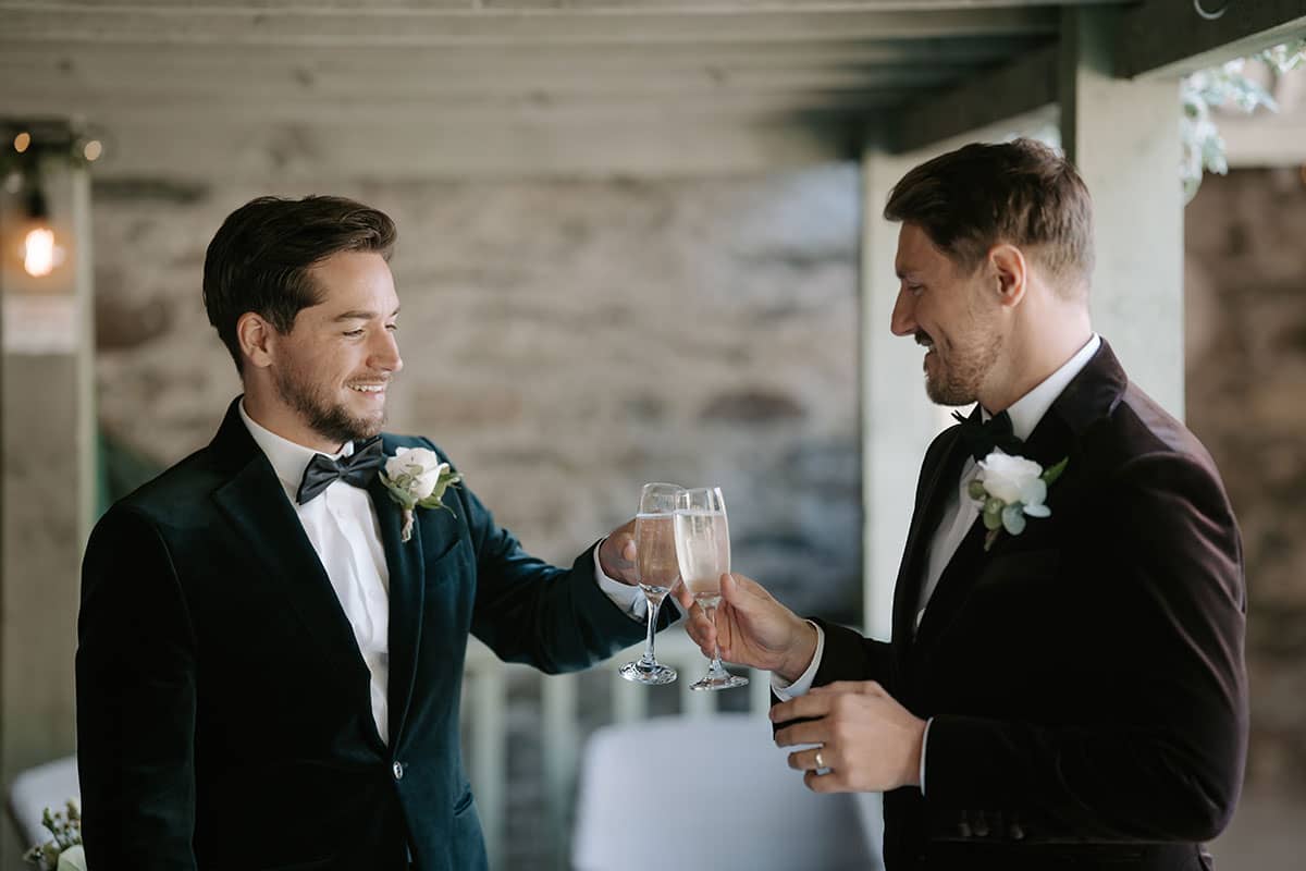 Gay wedding couple cheers as they celebrate after their Lake District elopement